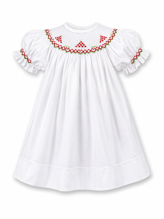 A white baby girl's smocked dress featuring puff sleeves, a smocked round neckline, and red and green embroidered geometric patterns around the collar and sleeve cuffs.