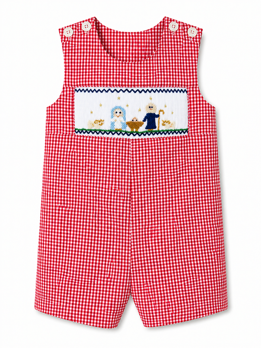 A baby boy's red and white gingham romper with a smocked chest panel featuring a Nativity scene with baby Jesus, Mary, and Joseph.