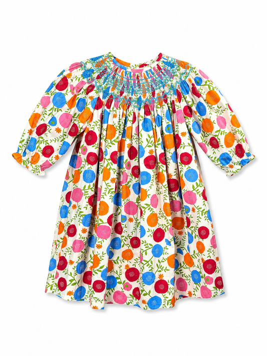 Bishop 3/4 sleeve baby dress with a colorful floral and fruit print on a cream background, featuring a smocked neckline and puff sleeves.