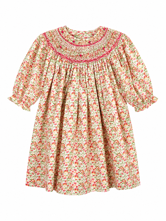 A 3/4 sleeve baby dress with a delicate red and green floral print on a cream background, featuring a smocked round neckline with pink embroidered trim.